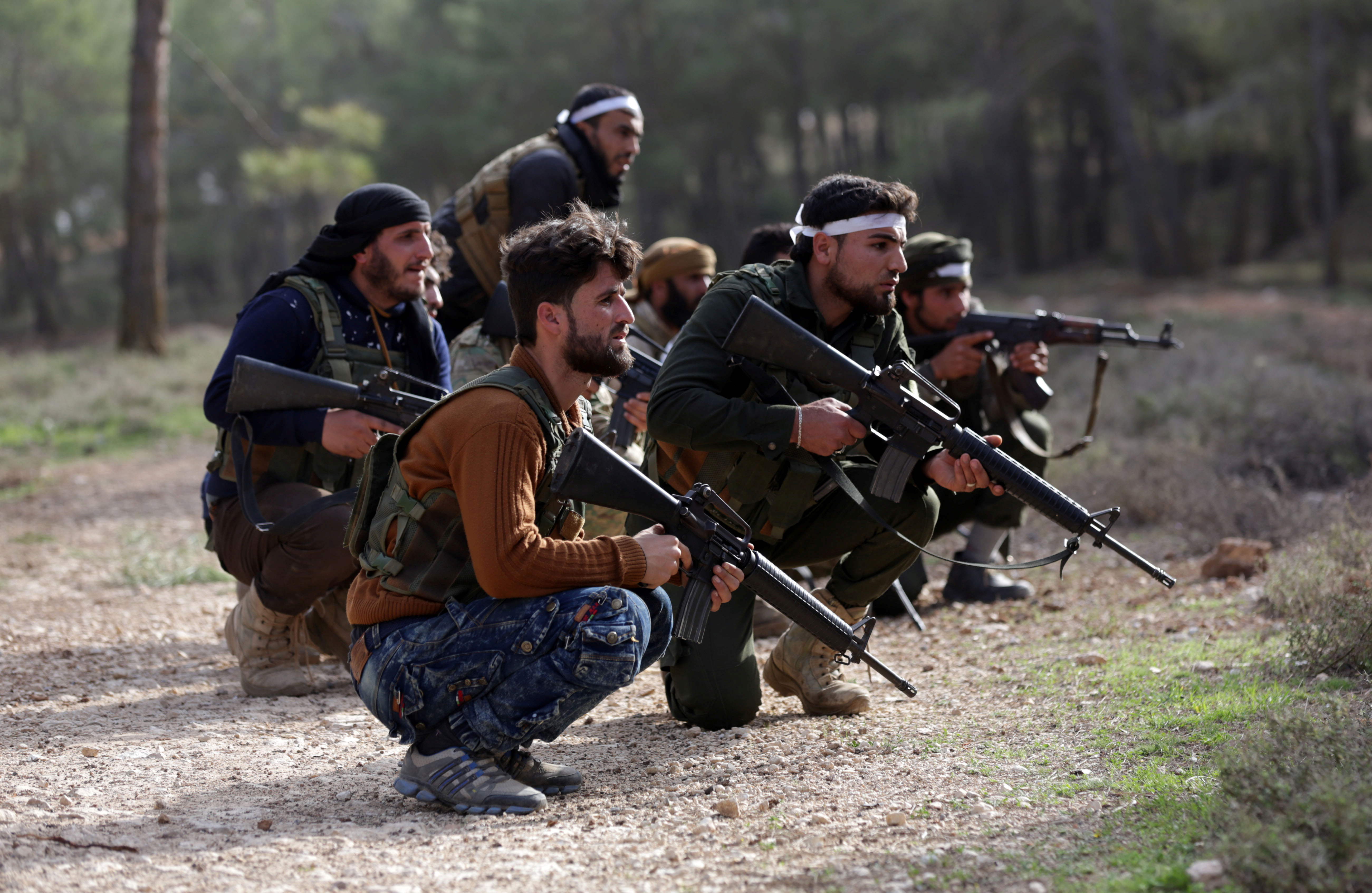 Turkish-backed Free Syrian Army fighters take up position as they advance north of Afrin, March 6, 2018.