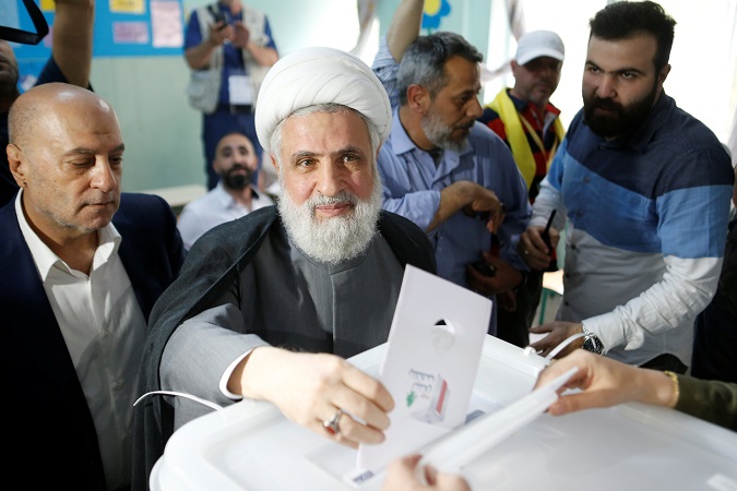 Lebanon's Hezbollah deputy leader Sheikh Naim Qassem casts his vote as he stands next to Hezbollah parliament candidate Amin Sherri at a polling station during the parliamentary election, in Beirut, Lebanon, May 6, 2018.