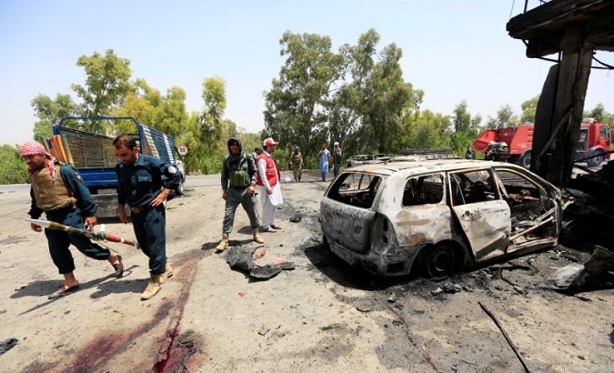Afghan policemen inspect the site of a suicide attack in Jalalabad city, Afghanistan July 10, 2018.