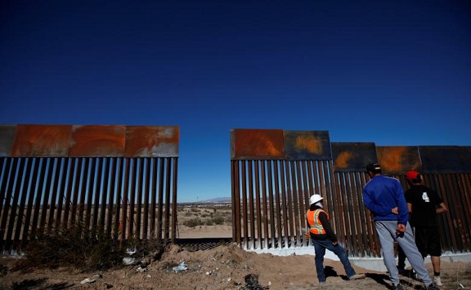 A worker chats with residents at a newly built section of the U.S.-Mexico border