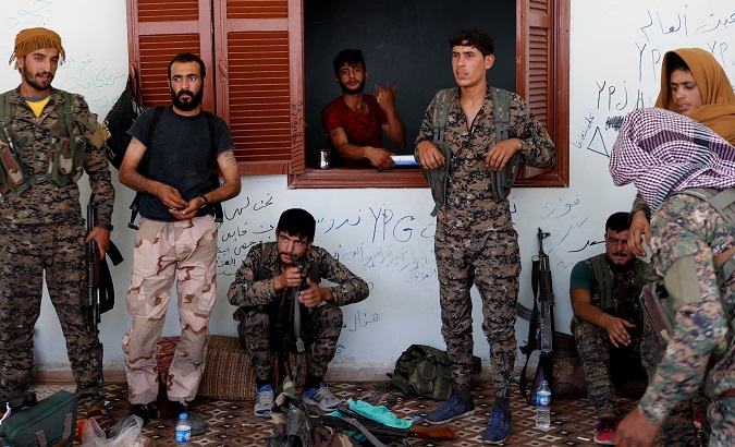 Kurdish fighters from the People's Protection Units (YPG) outside a house in Raqqa, Syria, June 2017.