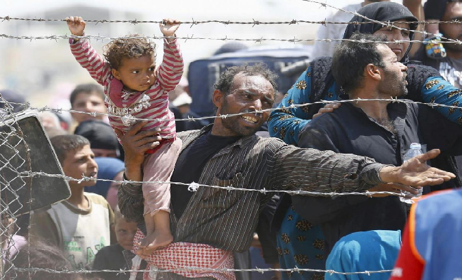 A Syrian refugee reacts as he waits behind border fences in Sanliurfa province, Turkey, June 15, 2015.