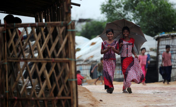 Rohingya refugee girls walk along the Kutupalong camp in Cox's Bazar, Bangladesh, Oct. 13, 2018.