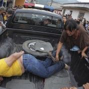 A woman hits a man with her shoes in Tactic, in Alta Verapaz region, some 189km (117 miles) from Guatemala City, September 13, 2012. The local community tied up and beat four men who were accused of theft in the aftermath of a school killing. REUTERS/Jorge Dan Lopez.