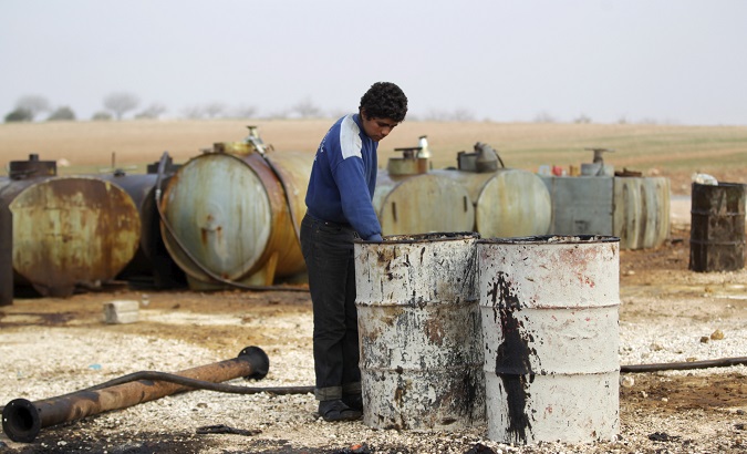 A youth works at an oil refinery site in Marchmarin town, Syria, Dec. 16, 2015.