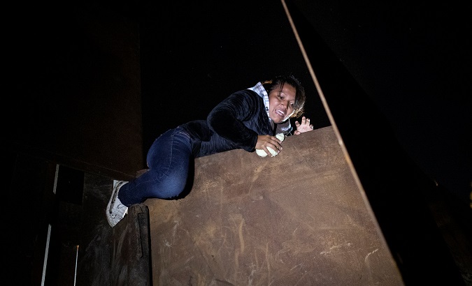 An asylum seeker, part of a caravan of thousands from Central America jumping a border fence from Mexico to the U.S, in Tijuana, Mexico, Dec. 3, 2018