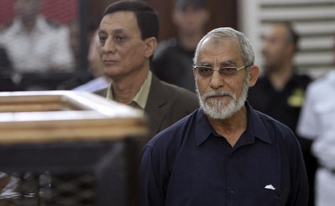 Muslim Brotherhood's Supreme Guide Mohamed Badie (R) looks on during his trial at a court in Cairo, May 18, 2014.
