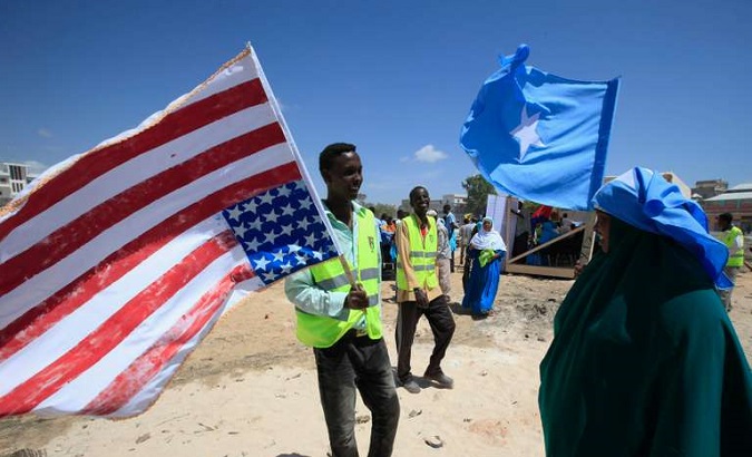 A man holds up an American flag and a woman holds a Somali flag in Mogadishu, Somalia, in January 2013.