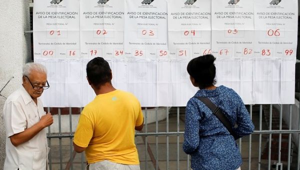 People find their names on the electoral rolls as they vote in Venezuela's municipal elections