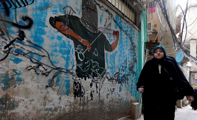 A woman walks past a graffiti in Burj al-Barajneh refugee camp in Beirut, Lebanon, Picture taken Jan. 29, 2018.