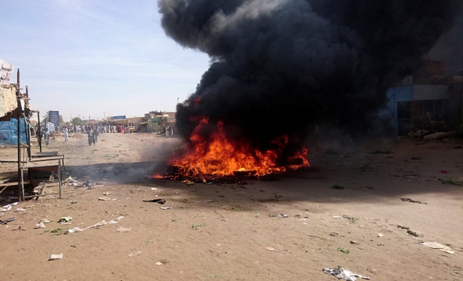 A bonfire sends up smoke during protests against price increases in Atbara, Sudan.