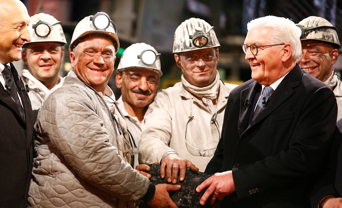 Miners and German President Frank-Walter Steinmeier pose with the symbolic last piece of stone coal in Bottrop, Germany, Dec. 21, 2018.