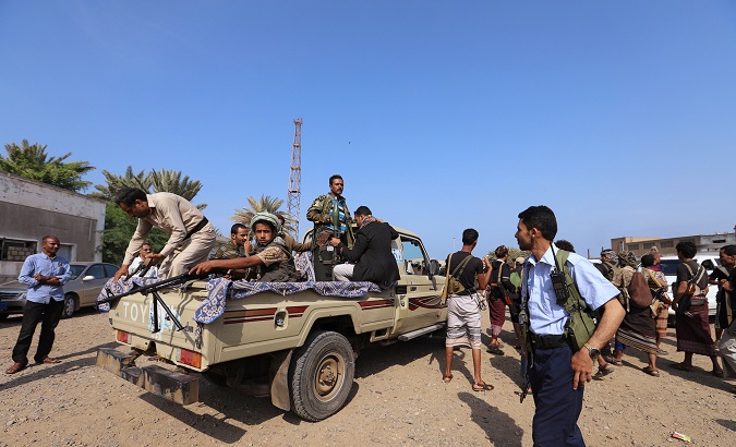 Houthis ride on the back of a truck as they withdraw, as part of a U.N.-sponsored peace agreement.