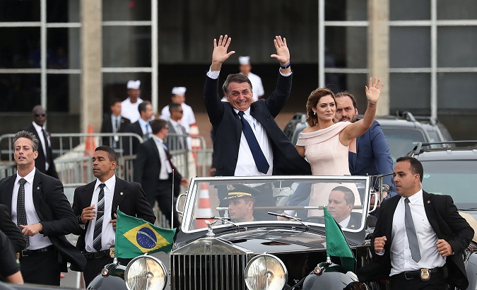 Brazil's new President Jair Bolsonaro and his wife Michelle wave as they drive past before his swear-in ceremony, in Brasilia, Brazil Jan. 1, 2019.