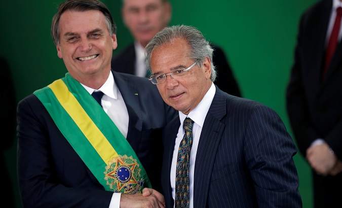 President Jair Bolsonaro (L) shakes hands with Paulo Guedes, economy minister, in Brasilia, Brazil Jan. 1, 2019.
