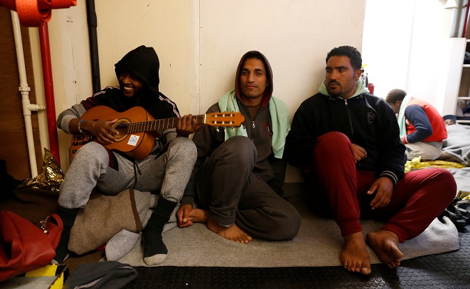A migrant plays a guitar while resting on the migrant search and rescue ship Sea-Watch 3, operated by German NGO Sea-Watch, off the coast of Malta in the central Mediterranean Sea January 3, 2019.