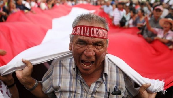Protesters carry A Peruvian flag during anti-corruption protests in Lima.