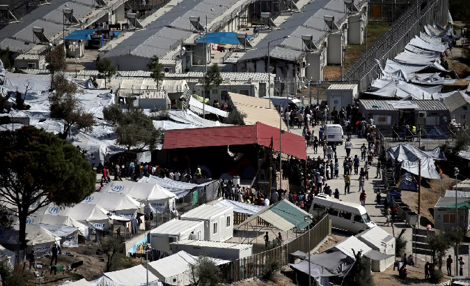 Refugees and migrants line up during food distribution at the Moria migrant camp on the island of Lesbos, Greece October 6, 2016