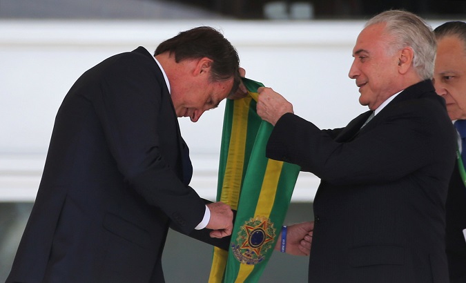 Brazil's new President Jair Bolsonaro receives the presidential sash from outgoing President Michel Temer at the Planalto Palace, in Brasilia, Brazil January 1, 2019.