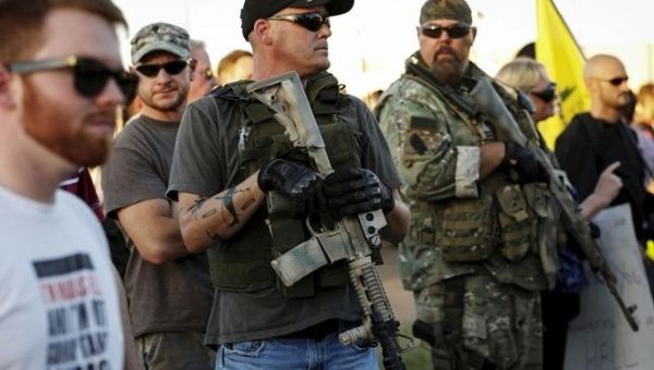 Men carrying rifles attend a 