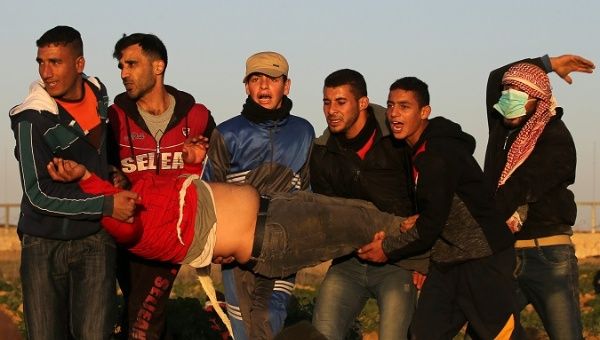 Palestinians evacuate a demonstrator during a protest at the Israel-Gaza border fence, January 11, 2019.