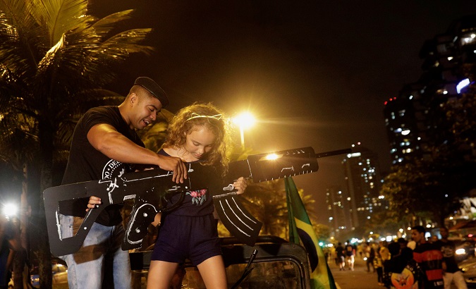 Supporters of Brazil's President Jair Bolsonaro, hold a cardboard gun, after Bolsonaro wins the presidential race, in Rio de Janeiro