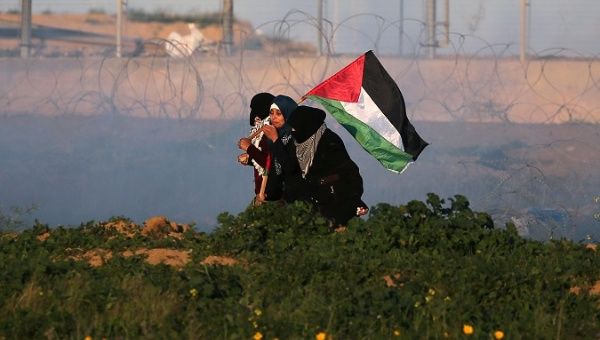 Palestinian demonstrators react from tear gas fired by Israeli troops during a protest at the Israel-Gaza border fence, in the southern Gaza Strip Jan. 18, 2019.