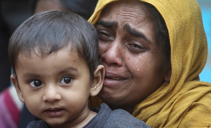 A Rohingya Muslim woman cries as she holds her daughter after they were detained by India's Border Security Force (BSF) soldiers on Jan. 22, 2019.