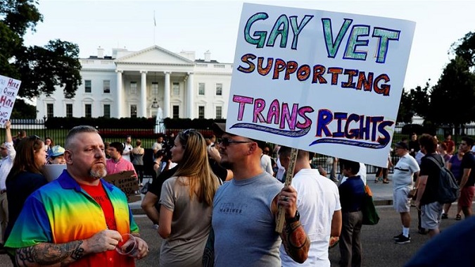 Demonstrators gather to protest US President Donald Trump's announcement that he plans to reinstate a ban on transgender individuals serving in any capacity in the US military