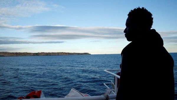 A migrant stands on the deck of the migrant search and rescue ship Sea-Watch 3, operated by German NGO Sea-Watch, off the coast of Malta, Jan. 8, 2019.
