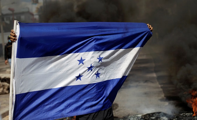 A demonstrator holds a Honduran flag during a protest against Honduras' President Juan Orlando Hernandez and his government in Tegucigalpa, Honduras, Jan 27, 2019.