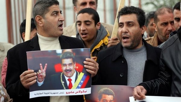 Palestinians hold pictures of Venezuela's President Nicolas Maduro during a rally in support of Maduro, in Gaza City Jan. 28, 2019