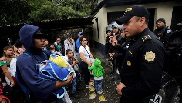 Migrants interact with a Guatemalan police officer in Esquipulas, Guatemala, Jan. 20, 2019.