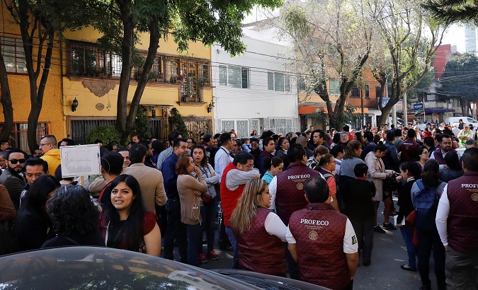 Office workers are seen at a street following an earthquake in Mexico City, Mexico Feb. 1, 2019.