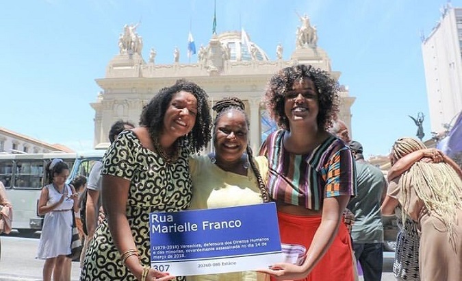 Dani Monteiro with a sign for a street named after murdered lawmaker Marielle Franco.
