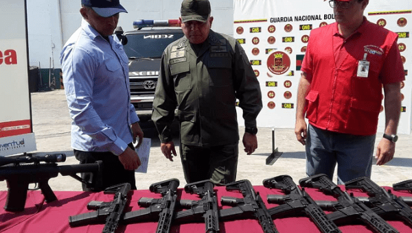 Venezuelan authorities with the seized weapons. 