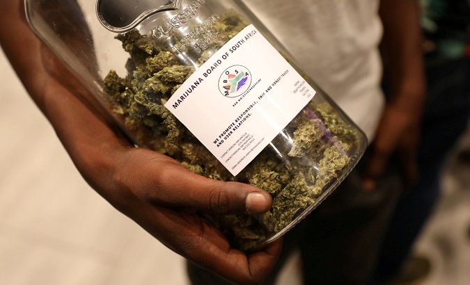 A man holds a jar of cannabis buds at an expo in Pretoria, South Africa.