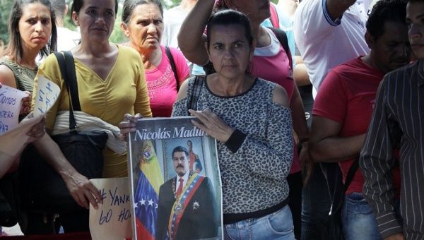 A woman holds an image of Venezuela's President Maduro as she attends a rally with pro-government supporters in San Antonio.