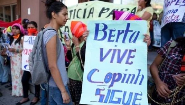 A demonstrator in Honduras holds a sign that reads, 
