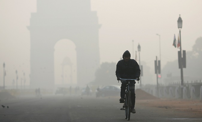 A man rides his bicycle in front of the India Gate shrouded in smog in New Delhi.