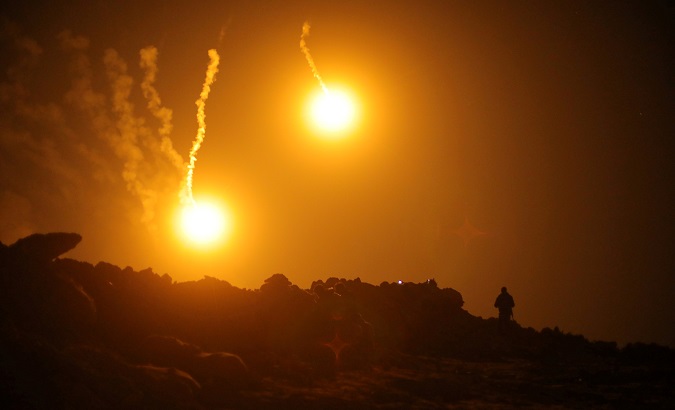 Flares are seen in the sky during fighting in the Islamic State's final enclave, in the village of Baghouz, Deir Al Zor province, Syria March 11, 2019.