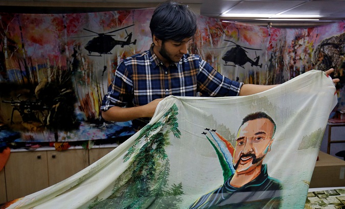 A salesman displays a sari with a printed image of Indian Air Force pilot Abhinandan Varthaman, who was captured and later released by Pakistan, inside a sari manufacturing factory in Surat.