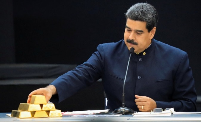 Venezuelan President Nicolas Maduro touches a gold bar as he speaks with economic officials at Miraflores Palace in Caracas in 2018.