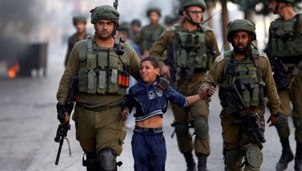 Israeli soldiers detain a Palestinian boy during clashes in the West Bank.