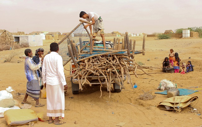 People are seen outside a makeshift hut after they have fled fighting, in Abs of the northwestern province of Hajja, Yemen March 29, 2019