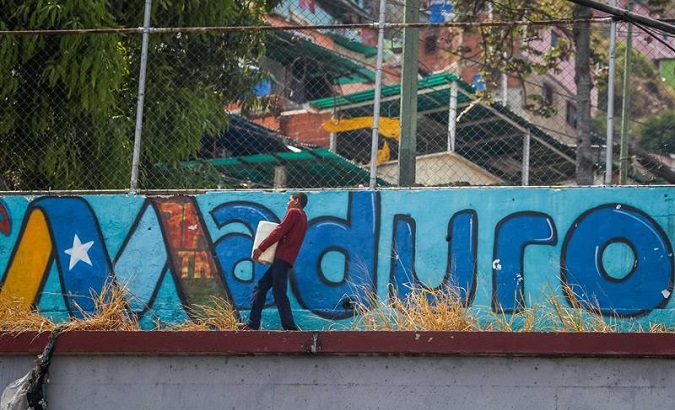 Man carries water after multiple attacks on Venezuela's water and electric system were executed by the United States, national officials allege.