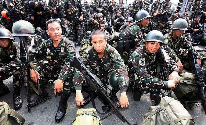 Filipino soldiers await orders to board a Navy ship.