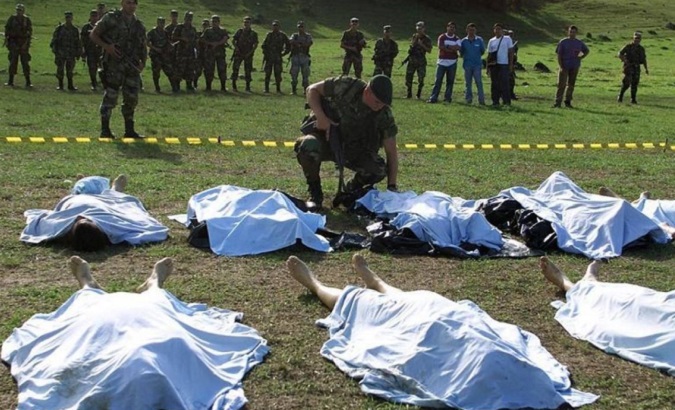 A Colombian soldier looks at the bodies of FARC rebels killed in combat in La Plata, Huila province, July 12, 2002