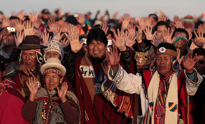 Bolivia's President Evo Morales standing amongst a group of Indigenous members.