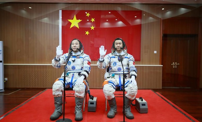 Representational: Chinese astronauts Jing Haipeng (L) and Chen Dong wave in front of a Chinese national flag before the launch of Shenzhou-11 , October 17, 2016